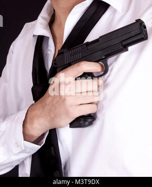 Man in black suit tenendo la pistola in mano. Agente segreto, mafia, concetto di guardia del corpo. Foto Stock