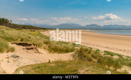 Llandwyn Bay di Anglesey, Gwynedd, Wales, Regno Unito - con Snowdonia mountain range in background Foto Stock