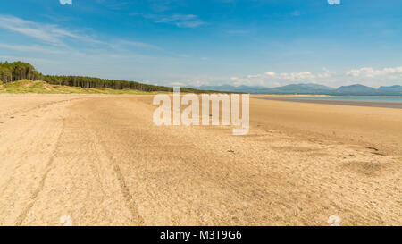 Llandwyn Bay di Anglesey, Gwynedd, Wales, Regno Unito - con Snowdonia mountain range in background Foto Stock