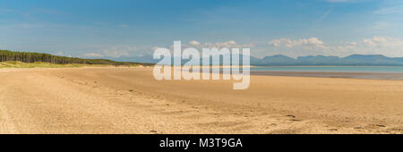 Llandwyn Bay di Anglesey, Gwynedd, Wales, Regno Unito - con Snowdonia mountain range in background Foto Stock