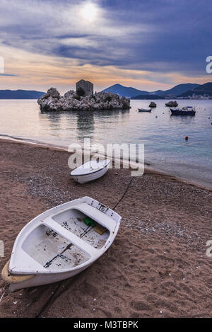 Piccola barca su una spiaggia in Przno resort villaggio sul mare Adriatico costa vicino a città di Budva Montenegro Foto Stock