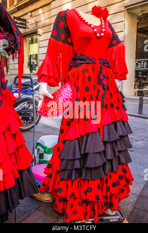 Bella tradizionali rosso vestito flamenco impiccato per la visualizzazione in un negozio in Spagna Foto Stock