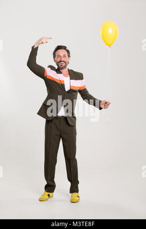 Uomo felice con palloncino giallo Foto Stock