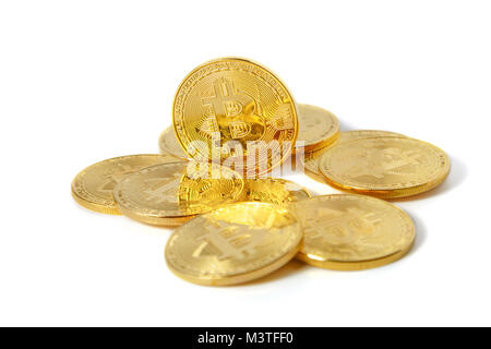 Diverse monete d oro con un segno di bitcoin giacciono su uno sfondo bianco Foto Stock