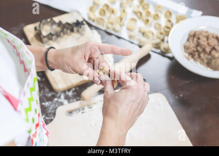 Il processo di realizzazione di deliziosi gnocchi fatti in casa. Sul tavolo della cucina è la posa di un riempimento, pronto a mangiare gnocchi e pasta. Foto Stock