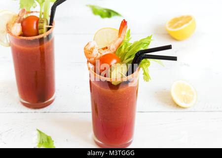 Bloody Mary Cocktail in bicchieri con contorni. Il pomodoro Bloody Mary bevanda piccante su sfondo bianco con copia spazio. Foto Stock