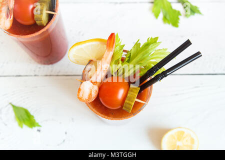 Bloody Mary Cocktail in bicchieri con contorni. Il pomodoro Bloody Mary bevanda piccante su sfondo bianco con copia spazio. Foto Stock