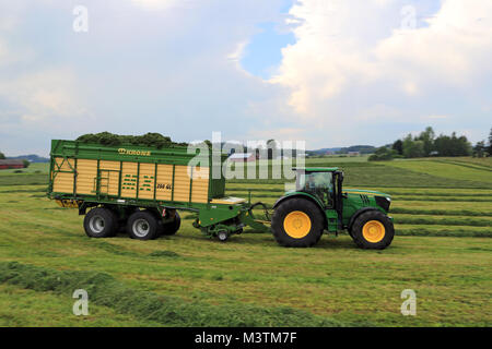 FORSSA, Finlandia - Luglio 20, 2014: John Deere 6210R il trattore e Krone MX 350 GL foraggio e carro scarica la raccolta di insilato. Uso del carro invece di tr Foto Stock