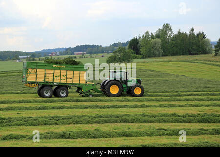 FORSSA, Finlandia - Luglio 20, 2014: John Deere 6210R il trattore e Krone MX 350 GL foraggio e carro scarica la raccolta di insilato. Uso del carro invece di tr Foto Stock