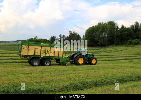 FORSSA, Finlandia - Luglio 20, 2014: John Deere 6210R trattore con Krone MX 350 GL rimorchio per il foraggio trasporta fieno tagliato. Uso del carro offre significativi utili Foto Stock