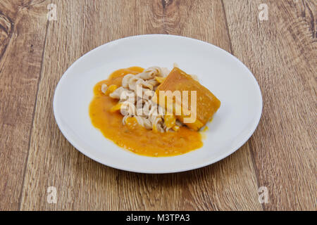 Il tofu e salsa di zucca con la pasta su una tavola di legno Foto Stock