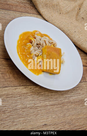 Il tofu e salsa di zucca con la pasta su una tavola di legno Foto Stock