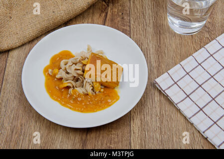 Il tofu e salsa di zucca con la pasta su una tavola di legno Foto Stock