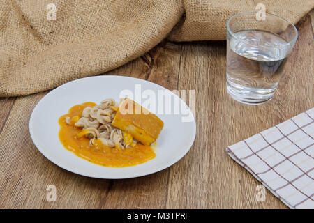 Il tofu e salsa di zucca con la pasta su una tavola di legno Foto Stock