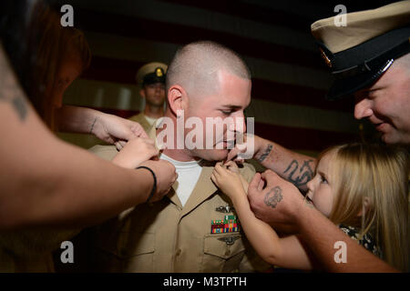 La base navale di KITSAP - BREMERTON, nello Stato di Washington (Sett. 16, 2015) Capo di Boatswain Mate David Smallwood, assegnato alla portaerei USS Nimitz CVN (68), riceve il suo ancore dai suoi amici e familiari durante la Nimitz' chief pinning cerimonia tenutasi a base navale Kitsap-Bremerton. Diciotto marinai a bordo Nimitz sono stati selezionati ed è imperniata al rango di chief petty officer, dopo aver partecipato ad un intenso, sei settimane del programma destinato a treno di prima classe sottufficiali su i ruoli e le responsabilità di diventare un capo.(STATI UNITI Foto di Marina di Massa lo specialista di comunicazione di terza classe Lauren K. JENNIN Foto Stock
