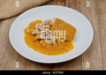 Il tofu e salsa di zucca con la pasta su una tavola di legno Foto Stock