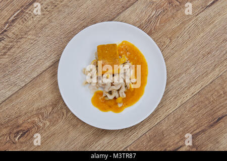 Il tofu e salsa di zucca con la pasta su una tavola di legno Foto Stock