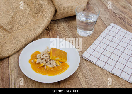 Il tofu e salsa di zucca con la pasta su una tavola di legno Foto Stock