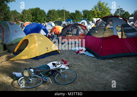 Un partecipante RAGBRAI riposa accanto alla sua bicicletta in uno dei molti campi aperti convertito in un campeggio in Webster City, Iowa. Qualsiasi disponibile park, cortile o il lotto è stato usato per il campeggio per accogliere le oltre 20.000 piloti. (U.S. Air Force foto/Staff Sgt. Julianne M. Showalter) Ragbrai014 da AirmanMagazine Foto Stock