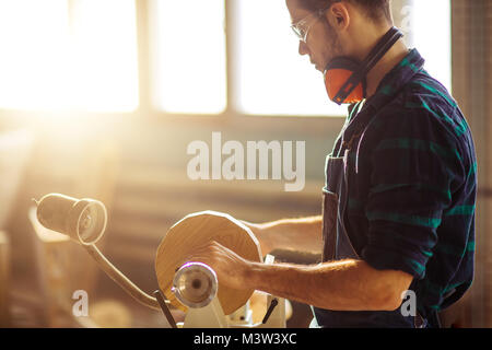 Attraente uomo iniziare facendo lavori in legno in falegnameria Foto Stock