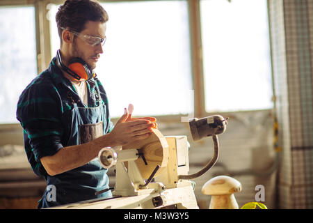 Attraente uomo iniziare facendo lavori in legno in falegnameria Foto Stock