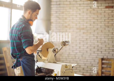 Attraente uomo iniziare facendo lavori in legno in falegnameria Foto Stock