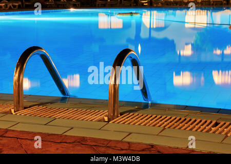 Acqua blu e corrimano per entrare nell'acqua. Foto Stock