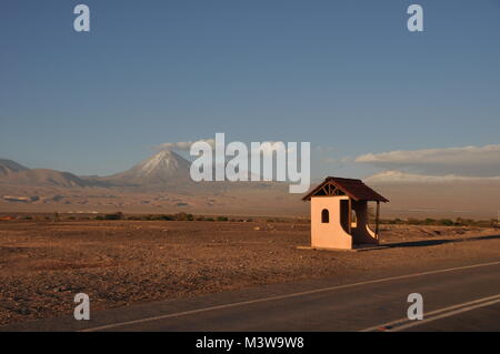 Un isolato fermata accanto a una strada di fronte ad una montagna di San Pedro de Atacama, Cile Foto Stock