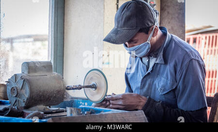 L'uomo facendo palette da zebù avvisatore acustico per turisti, Antsirabe, Madagascar Foto Stock