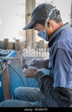 L'uomo facendo palette da zebù avvisatore acustico per turisti, Antsirabe, Madagascar Foto Stock