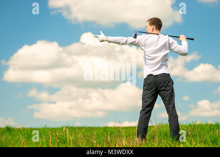Il golfer mostrando la sua mano per lo spazio sul lato sinistro del telaio, l'uomo con un club di golf Foto Stock