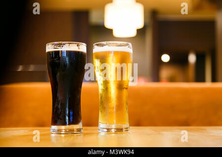 Due bicchieri di birra su uno sfondo scuro Foto Stock