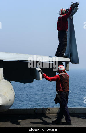 Golfo Arabico (25 luglio 2017) DEGLI STATI UNITI Navy Aviation Ordnanceman 2a classe Joshua Gerber, sopra, da Milwaukee e aviazione Ordnanceman Airman Eric Wolf, di seguito, da Virginia Beach, Virginia, secure ordnance per un'F/A-18F Super Hornet, dal "cavalieri neri" di Strike Fighter Squadron (VFA) 154, a bordo della portaerei USS Nimitz CVN (68), 25 luglio 2017, nel Golfo Arabico. Nimitz è distribuito negli Stati Uniti Quinta Flotta area di operazioni a sostegno di funzionamento inerenti a risolvere. Mentre in questa regione la nave e strike gruppo stanno conducendo le operazioni di sicurezza marittima per rassicurare gli alleati e partner Foto Stock