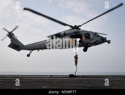 Golfo Arabico (Agosto 22, 2017) DEGLI STATI UNITI Navy esplosivo ordinanza personale di smaltimento partecipano in un fast roping esercizio con un MH-60S Sea Hawk elicottero, dal "Eightballers" di elicottero di mare squadrone di combattimento (HSC) 8, a bordo della portaerei USS Nimitz CVN (68), e il agosto 22, 2017, nel Golfo Arabico. Nimitz è distribuito negli Stati Uniti Quinta Flotta area di operazioni a sostegno di funzionamento inerenti a risolvere. Mentre in questa regione la nave e strike gruppo stanno conducendo le operazioni di sicurezza marittima per rassicurare gli alleati e partner, preservare la libertà di navigazione e di mantenere il flusso libero di commerc Foto Stock