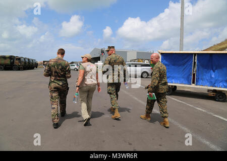 Un francese leader militare cammina con Anne Galegor, un rappresentante dell'Ufficio Stranieri di assistenza di emergenza; U.S. Marine Col. Michael V. Samarov, il comandante della Joint Task Force - Isole Sottovento; e Sgt. Il Mag. Glenn D. Bragg, JTF-LI sergente maggiore, a Grand Case Aeroporto in Saint Martin, Sett. 15, 2017. A richiesta delle nazioni partner, JTF-LI aeromobili impiegati e i membri del servizio ad aree nella zona orientale del Mar dei Caraibi colpiti dall uragano Irma. La joint task force è un militare statunitense di unità composta di Marines, soldati, marinai, aviatori, e rappresenta U.S. A sud del comando Foto Stock