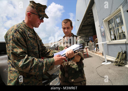 Stati Uniti Marine Col. Michael V. Samarov, il comandante della Joint Task Force - Isole Sottovento, discute Hurricane Relief Operations con un francese leader militare a Grand Case Aeroporto in Saint Martin, Sett. 15, 2017. A richiesta delle nazioni partner, JTF-LI aeromobili impiegati e i membri del servizio ad aree nella zona orientale del Mar dei Caraibi colpiti dall uragano Irma. La joint task force è un militare statunitense di unità composta di Marines, soldati, marinai, aviatori, e rappresenta U.S. Comando Sud la risposta primaria a uragano Irma. (U.S. Foto dell'esercito da Capt. Trisha nero) 170915-A-GF676-340 da ussouth Foto Stock