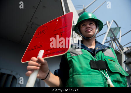 Golfo Arabico (17 agosto 2013) Boatswain compagno del 3° di classe Stephanie Ramsey agisce come segnalatore durante un rifornimento in corso a bordo guidato-missile destroyer USS William Lawrence (DDG 110). William P. Lawrence è distribuito negli Stati Uniti Quinta Flotta area di responsabilità promuovere le operazioni di sicurezza marittima, teatro la cooperazione in materia di sicurezza gli sforzi e le missioni di sostegno per l'Operazione Enduring Freedom. (U.S. Foto di Marina di Massa lo specialista di comunicazione di terza classe Carla Ocampo/RILASCIATO) 003 22 Agosto il lotto 1 di 8 Foto Stock