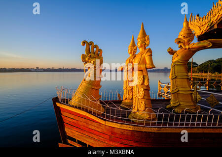 Golden statue sono decorare il Gen. Pyi Gyi Mon Royal Barge, una piscina ristorante galleggiante sul Lago Kandawgyi presso sunrise Foto Stock