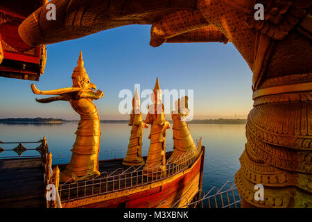 Golden statue sono decorare il Gen. Pyi Gyi Mon Royal Barge, una piscina ristorante galleggiante sul Lago Kandawgyi presso sunrise Foto Stock