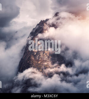 Majestical montagne in nubi in serata a sopraggitto in Nepal. Paesaggio con belle e alte rocce e drammatico cielo nuvoloso con la luce del sole al tramonto. Natu Foto Stock