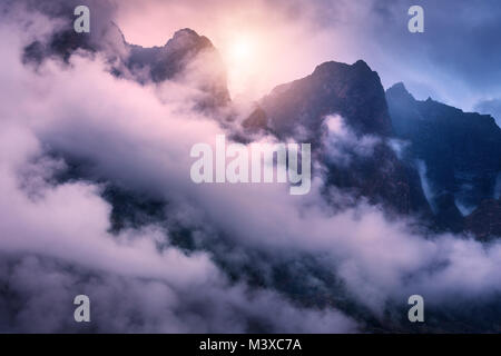 Majestical montagne in nuvole nel cielo coperto serata colorata in Nepal. Paesaggio con belle e alte rocce e drammatica viola cielo nuvoloso al tramonto. Na Foto Stock