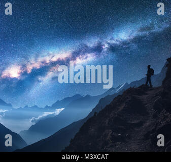 Spazio con Via Lattea, ragazza e le montagne. Silhouette di donna in piedi sul picco di montagna, le montagne e il cielo stellato di notte in Nepal. Sky con stella Foto Stock