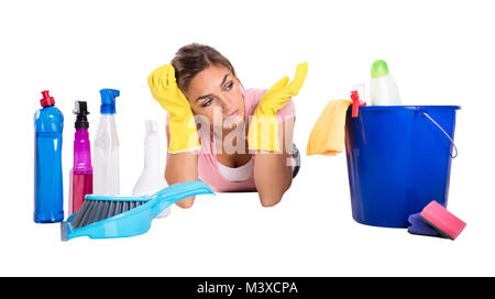 Close-up di un Giovane Femmina bidello giacente su sfondo bianco in prossimità di prodotti per la pulizia Foto Stock