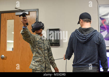 Un 366 Training Squadron impianti elettrici apprendista studente del corso a Sheppard Air Force Base in Texas, raggiunge fuori mentre in realtà virtuale, mentre James Rumfelt, un digital designer di Sheppard AFB, sovrintende gen. 26, 2018 a Sheppard AFB. Gli studenti sono stati invitati, e detto, a partecipare a una dimostrazione di tech ospitato dal digital design lab di Sheppard AFB. Gli studenti dovevano immettere mondo della realtà virtuale e quindi fornire un feedback su quello che pensa il potenziale uso di esso nell'ambiente di formazione. (U.S. Air Force foto di Airman Prima Classe Pedro Tenorio) Foto Stock