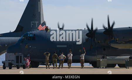 Stati Uniti Air Force Capt. Bryan Singer, 79th Rescue Squadron sistemi di combattimento ufficiale, visualizza la bandiera americana dalla cima di un HC-130J contro il re II dopo il ritorno da una distribuzione a sostegno della Combined Joint Task Force inerente operazione risolvere al momento Davis-Monthan Air Force Base, Ariz., 6 febbraio 2018. I membri sia dalla 79th RQS e il 923rd Manutenzione aeromobili squadrone restituito dopo un giorno 120 deployment in cui erano in stato di allerta per combattere la ricerca e il salvataggio e il recupero del personale delle missioni. (U.S. Air Force photo by Staff Sgt. Chris Drzazgowski) Foto Stock