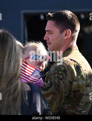 Stati Uniti Air Force Capt. Adam Kling, 79th Rescue Squadron HC-130J pilota, mantiene la sua figlia dopo il ritorno da una distribuzione a sostegno della Combined Joint Task Force inerente operazione risolvere al momento Davis-Monthan Air Force Base, Ariz., 6 febbraio 2018. I membri sia dalla 79th RQS e il 923rd Manutenzione aeromobili squadrone restituito dopo un giorno 120 deployment in cui erano in stato di allerta per combattere la ricerca e il salvataggio e il recupero del personale delle missioni. (U.S. Air Force photo by Staff Sgt. Chris Drzazgowski) Foto Stock