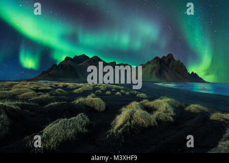 Islanda paesaggio notturno fantastici Northern Light in vestrahorn montagna nera con dune di sabbia a stokksnes Foto Stock