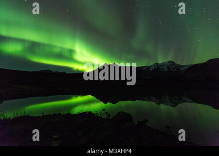 Green aurora luce dietro il lago di montagna in Islanda Europa al parco nazionale di skaftafell Foto Stock