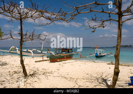 Paesaggio panoramico. Tramonto a Gili Meno isola. Lombok, Indonesia. Alcune barche da pesca resto nella sabbia della spiaggia della zona Ovest dell'isola, Foto Stock