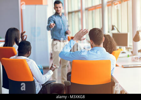 Gruppo di casualmente vestito imprenditori discutere le idee in ufficio. Foto Stock